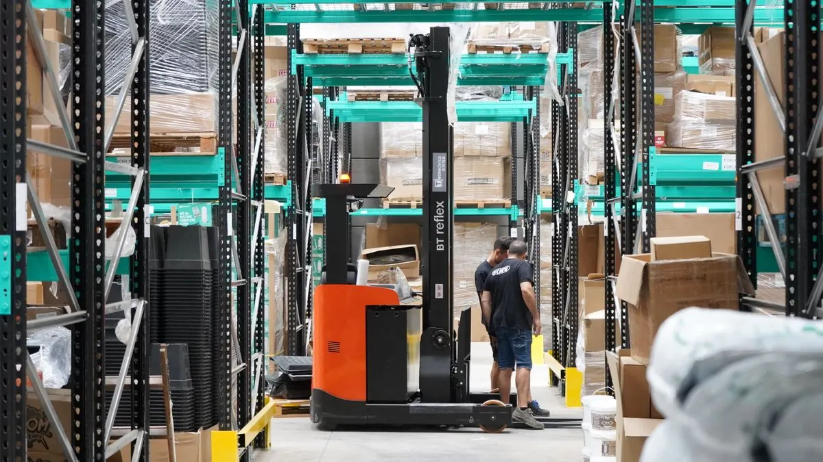Warehouse storage racks and a forklift in an aisle