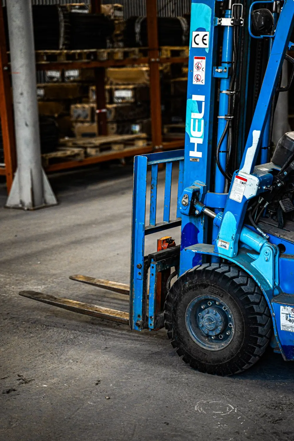 Blue forklift mast and forks inside a warehouse